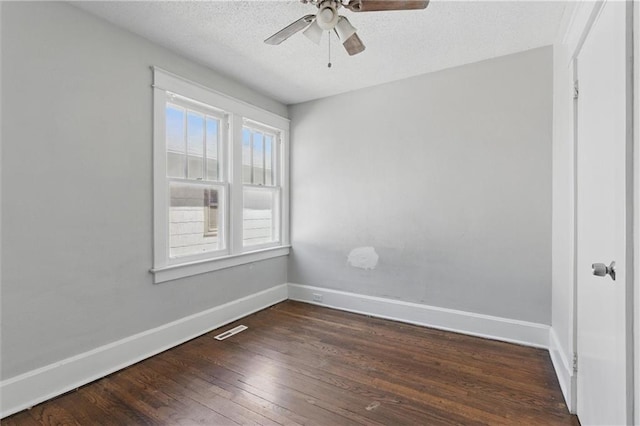 unfurnished room featuring visible vents, a ceiling fan, baseboards, and dark wood-style floors
