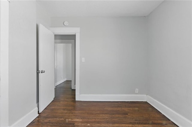 empty room with baseboards and dark wood-style flooring