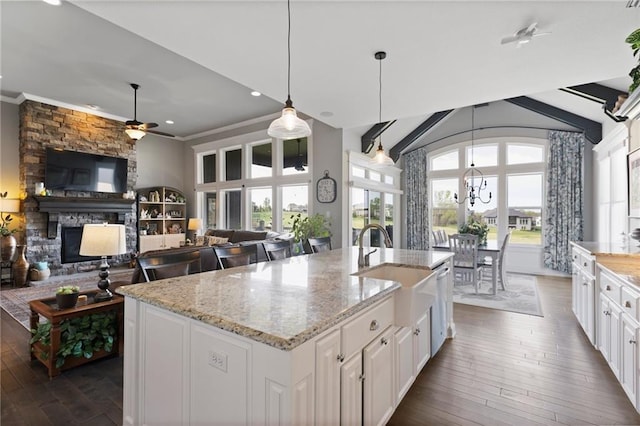 6840 Belmont Dr, Shawnee, KS 66226 - kitchen featuring ceiling fan with notable chandelier, a sink, dark wood-style floors, and a fireplace