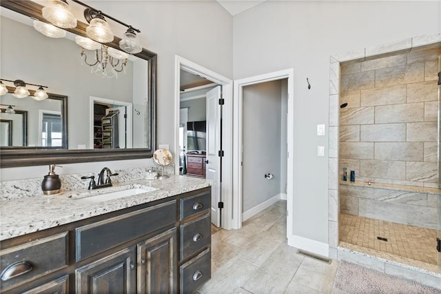 6840 Belmont Dr, Shawnee, KS 66226 - full bath featuring vanity, a tile shower, baseboards, a notable chandelier, and tile patterned flooring