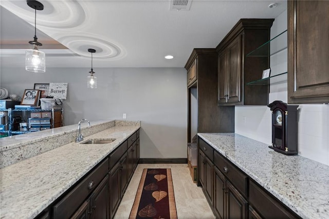 6840 Belmont Dr, Shawnee, KS 66226 - kitchen featuring visible vents, a sink, light stone countertops, dark brown cabinetry, and hanging light fixtures
