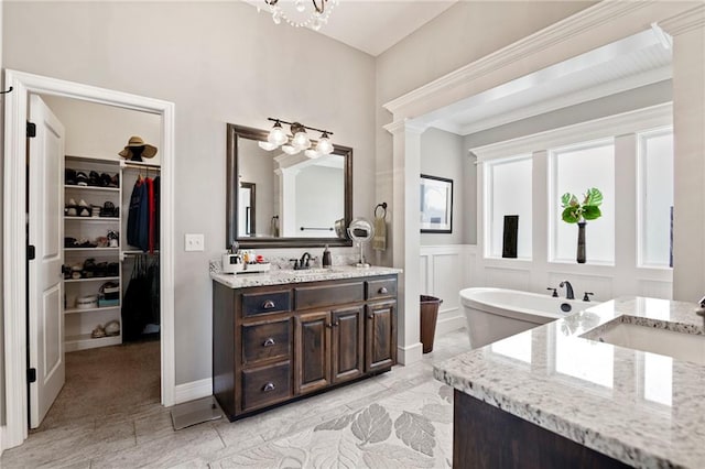 6840 Belmont Dr, Shawnee, KS 66226 - bathroom with two vanities, a walk in closet, a freestanding bath, a chandelier, and a decorative wall