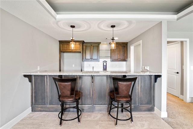 6840 Belmont Dr, Shawnee, KS 66226 - kitchen with a peninsula, a kitchen bar, light stone countertops, and backsplash