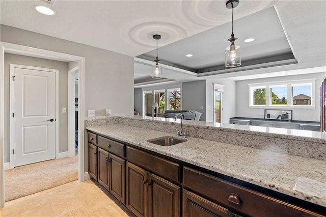6840 Belmont Dr, Shawnee, KS 66226 - kitchen with a raised ceiling, light stone countertops, hanging light fixtures, dark brown cabinets, and recessed lighting