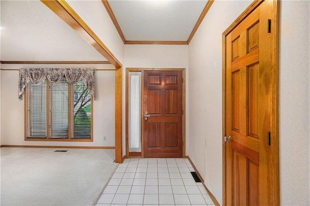 foyer entrance featuring light carpet, baseboards, visible vents, a textured ceiling, and crown molding