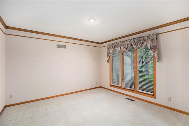 empty room featuring baseboards, ornamental molding, and light carpet