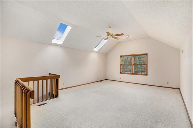 additional living space with lofted ceiling with skylight, visible vents, carpet flooring, and baseboards