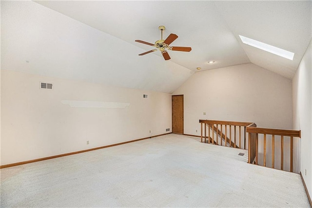 additional living space featuring carpet floors, visible vents, a ceiling fan, and vaulted ceiling with skylight