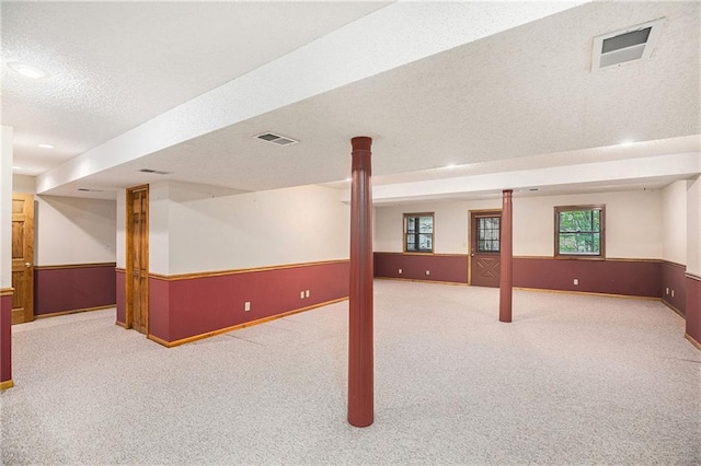 basement with visible vents, carpet flooring, and baseboards