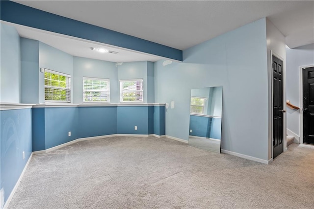 carpeted spare room with plenty of natural light and baseboards