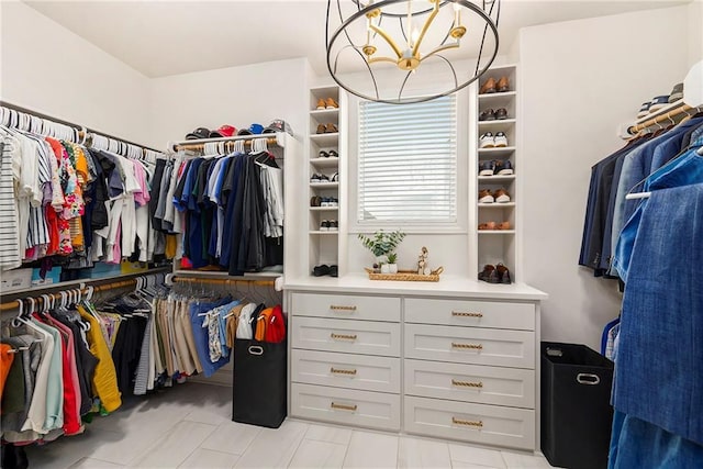 walk in closet featuring light tile patterned flooring and a notable chandelier