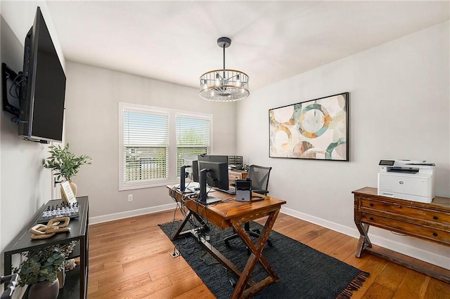 office area with an inviting chandelier, light wood finished floors, and baseboards