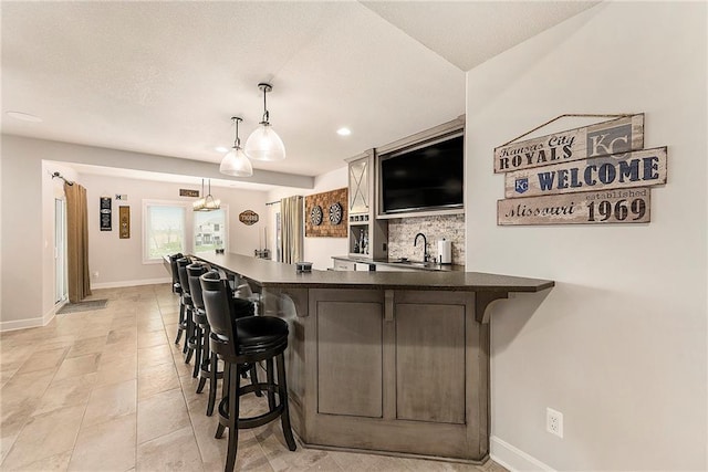 bar featuring a sink, baseboards, recessed lighting, decorative backsplash, and decorative light fixtures