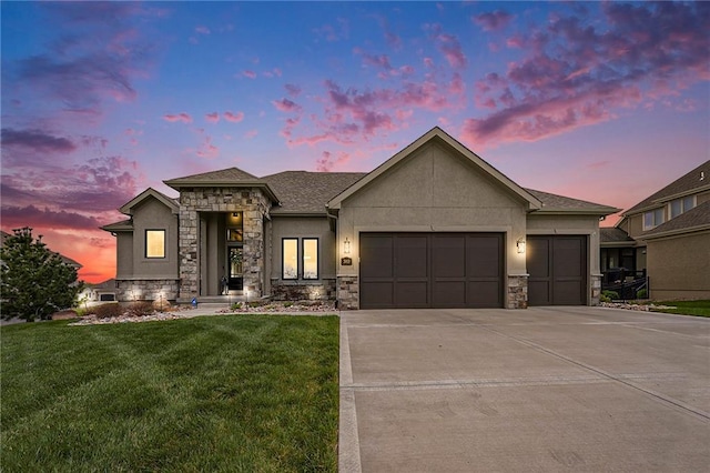 view of front of property with a front lawn, driveway, stone siding, an attached garage, and stucco siding