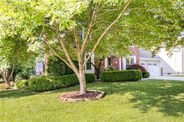 obstructed view of property featuring concrete driveway, a front lawn, an attached garage, and brick siding