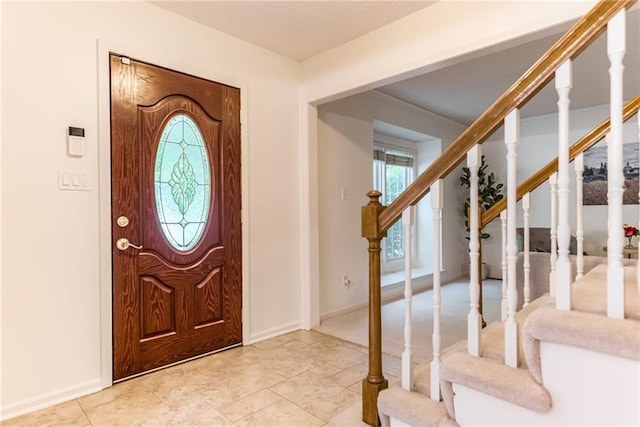 entrance foyer featuring stairs and baseboards