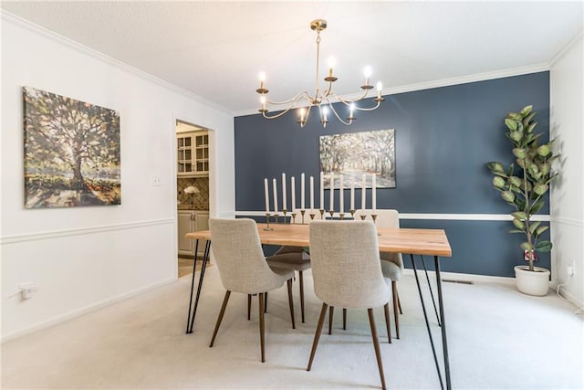 carpeted dining space with a chandelier, ornamental molding, and baseboards