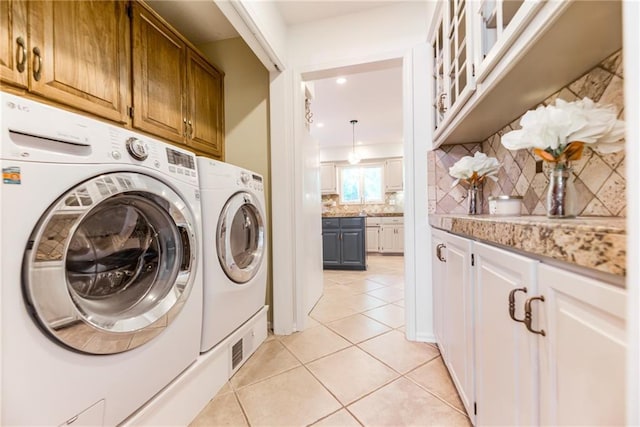 clothes washing area with separate washer and dryer, light tile patterned floors, cabinet space, and recessed lighting