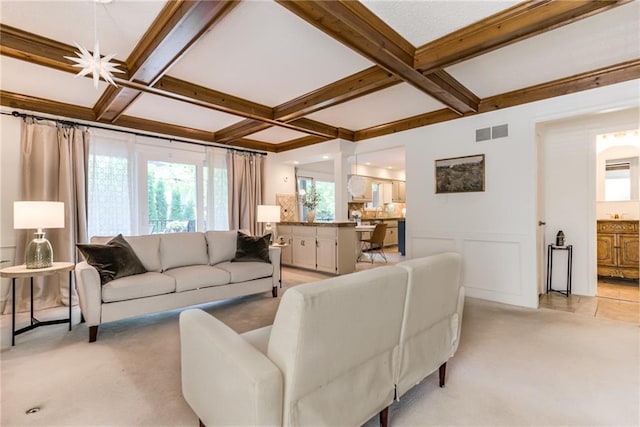 living area featuring coffered ceiling, beam ceiling, and light carpet