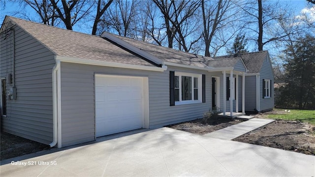 view of front of property with concrete driveway, roof with shingles, solar panels, and an attached garage