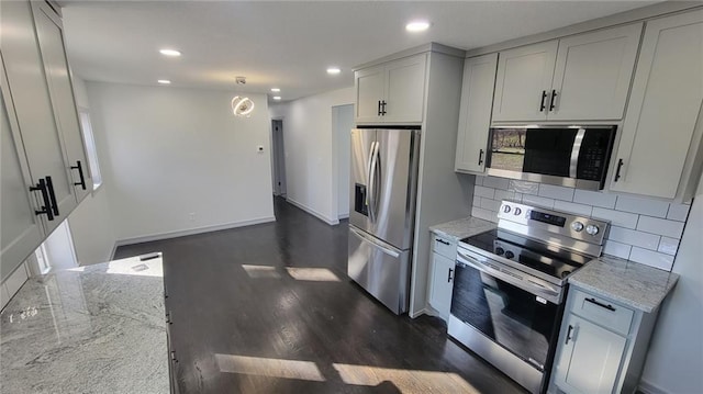 kitchen with stainless steel appliances, light stone countertops, backsplash, recessed lighting, and dark wood finished floors