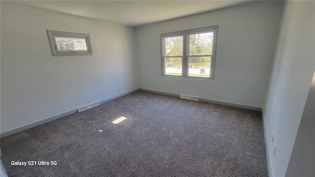 carpeted spare room with plenty of natural light and baseboards
