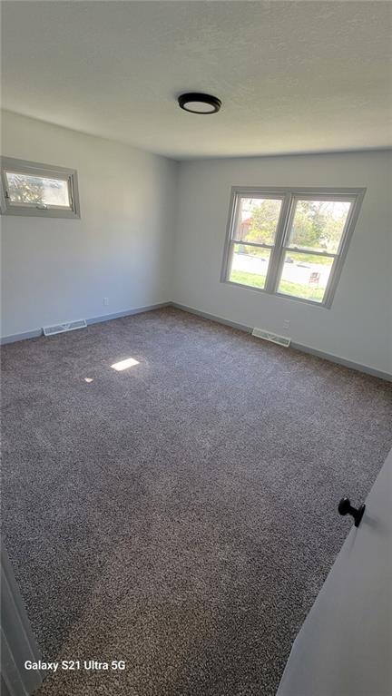 carpeted spare room with baseboards