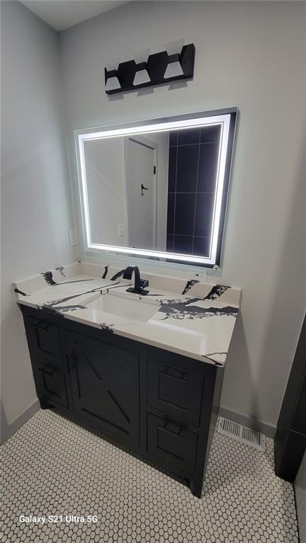 bathroom with vanity, baseboards, and tile patterned flooring