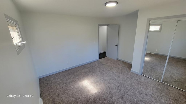 unfurnished bedroom featuring a closet, carpet floors, and baseboards