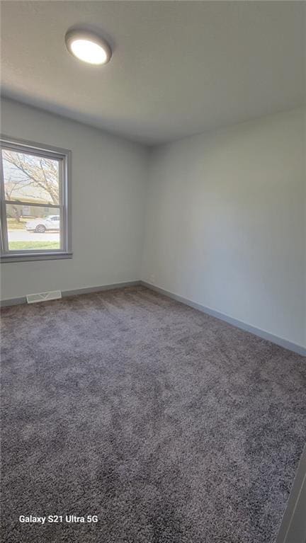 unfurnished room with carpet flooring and baseboards