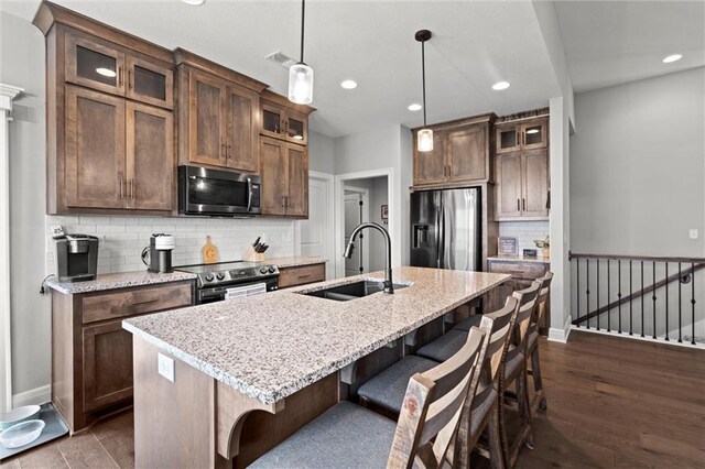 1002 Fox Trot Dr, Odessa, MO 64076 - kitchen with appliances with stainless steel finishes, a sink, a breakfast bar area, recessed lighting, and tasteful backsplash