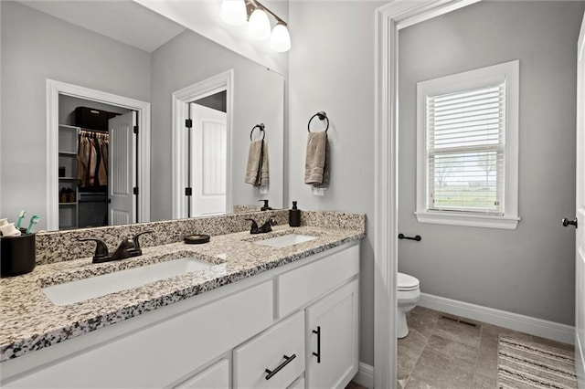 1002 Fox Trot Dr, Odessa, MO 64076 - full bath featuring double vanity, toilet, baseboards, and a spacious closet