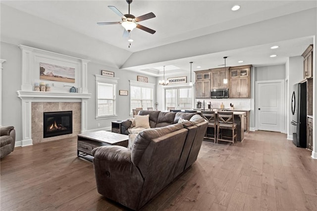 1002 Fox Trot Dr, Odessa, MO 64076 - living room featuring wood finished floors, a ceiling fan, plenty of natural light, a tile fireplace, and recessed lighting