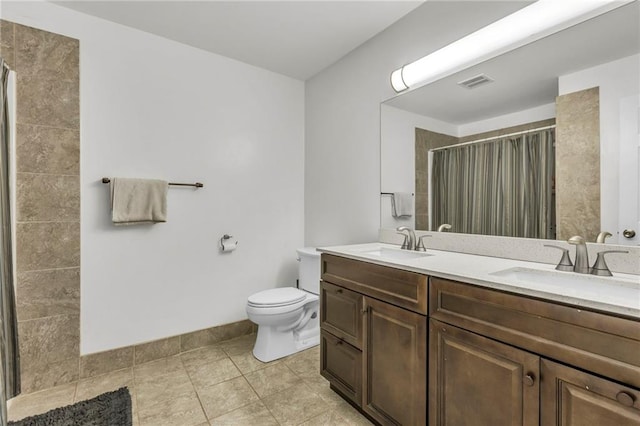 full bath featuring visible vents, a sink, a shower with shower curtain, and toilet