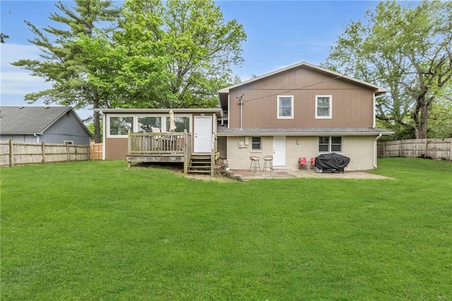 back of property with a patio, a deck, a yard, and a fenced backyard