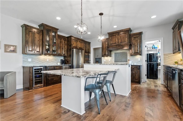 kitchen featuring appliances with stainless steel finishes, wine cooler, decorative backsplash, recessed lighting, and dark brown cabinetry