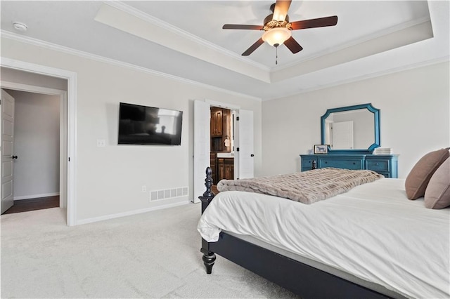 bedroom with a raised ceiling, ornamental molding, light colored carpet, baseboards, and a ceiling fan
