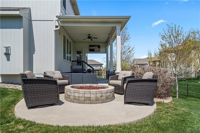 view of patio / terrace with a ceiling fan and an outdoor living space with a fire pit