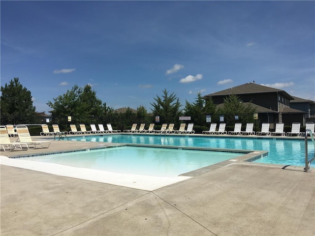 community pool with fence and a patio