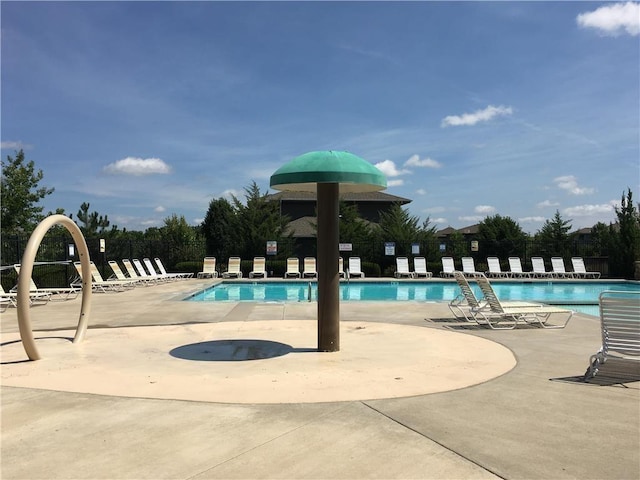 community pool with fence and a patio area