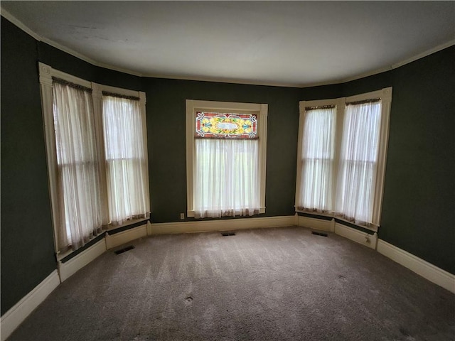 carpeted spare room with visible vents and baseboards