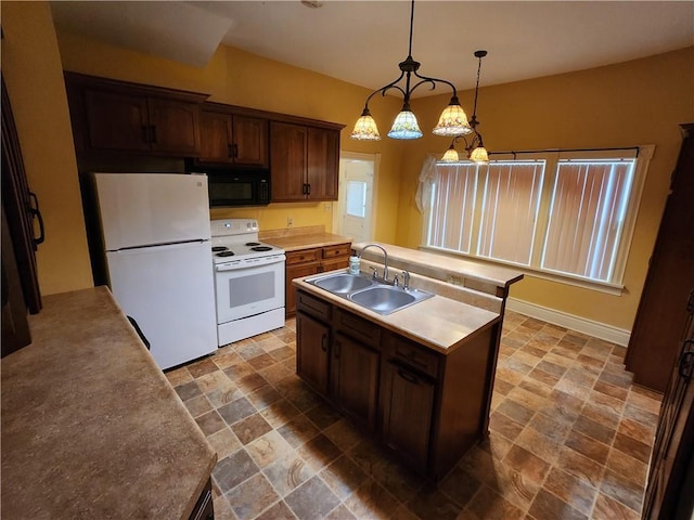 kitchen with an island with sink, a sink, white appliances, and stone finish flooring