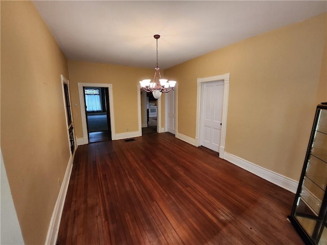 unfurnished dining area with a chandelier, baseboards, visible vents, and hardwood / wood-style flooring