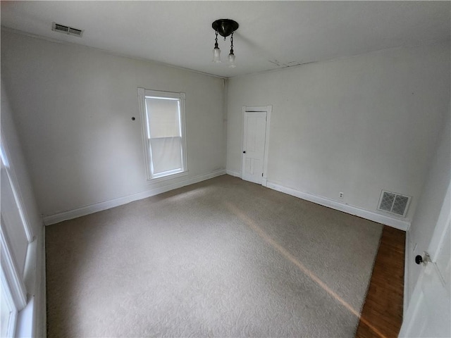 unfurnished room with visible vents and baseboards