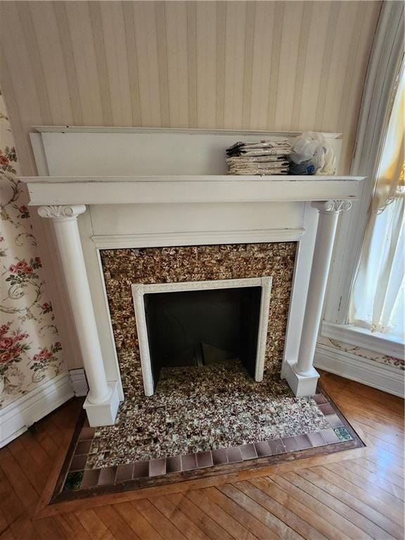 details featuring a fireplace, baseboards, and wood finished floors