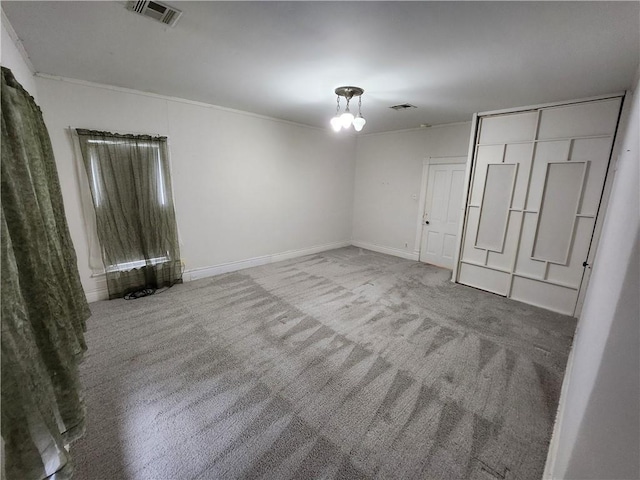 unfurnished bedroom featuring crown molding, visible vents, baseboards, and carpet flooring