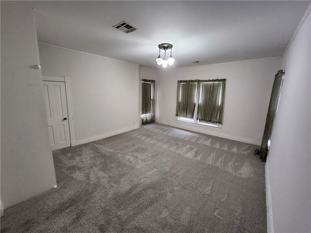 carpeted spare room featuring crown molding, baseboards, and visible vents