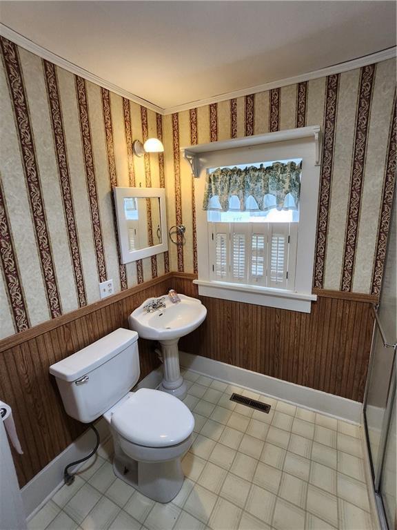 bathroom featuring wallpapered walls, tile patterned floors, toilet, a wainscoted wall, and visible vents