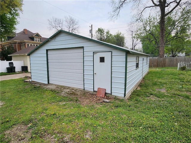 view of outdoor structure with fence and an outbuilding