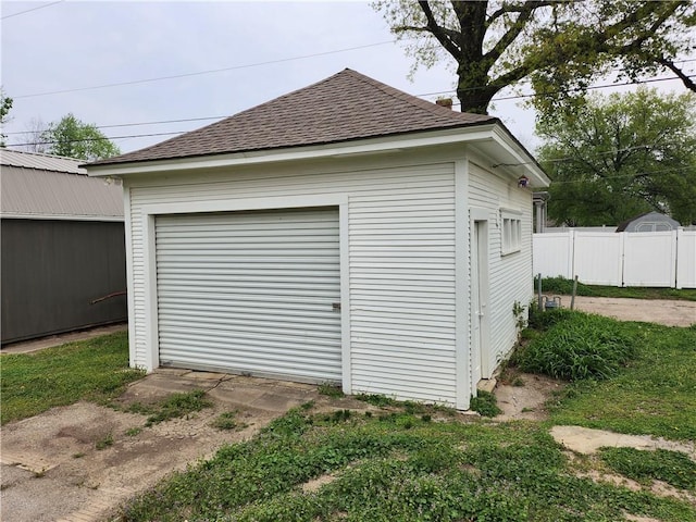 detached garage featuring fence